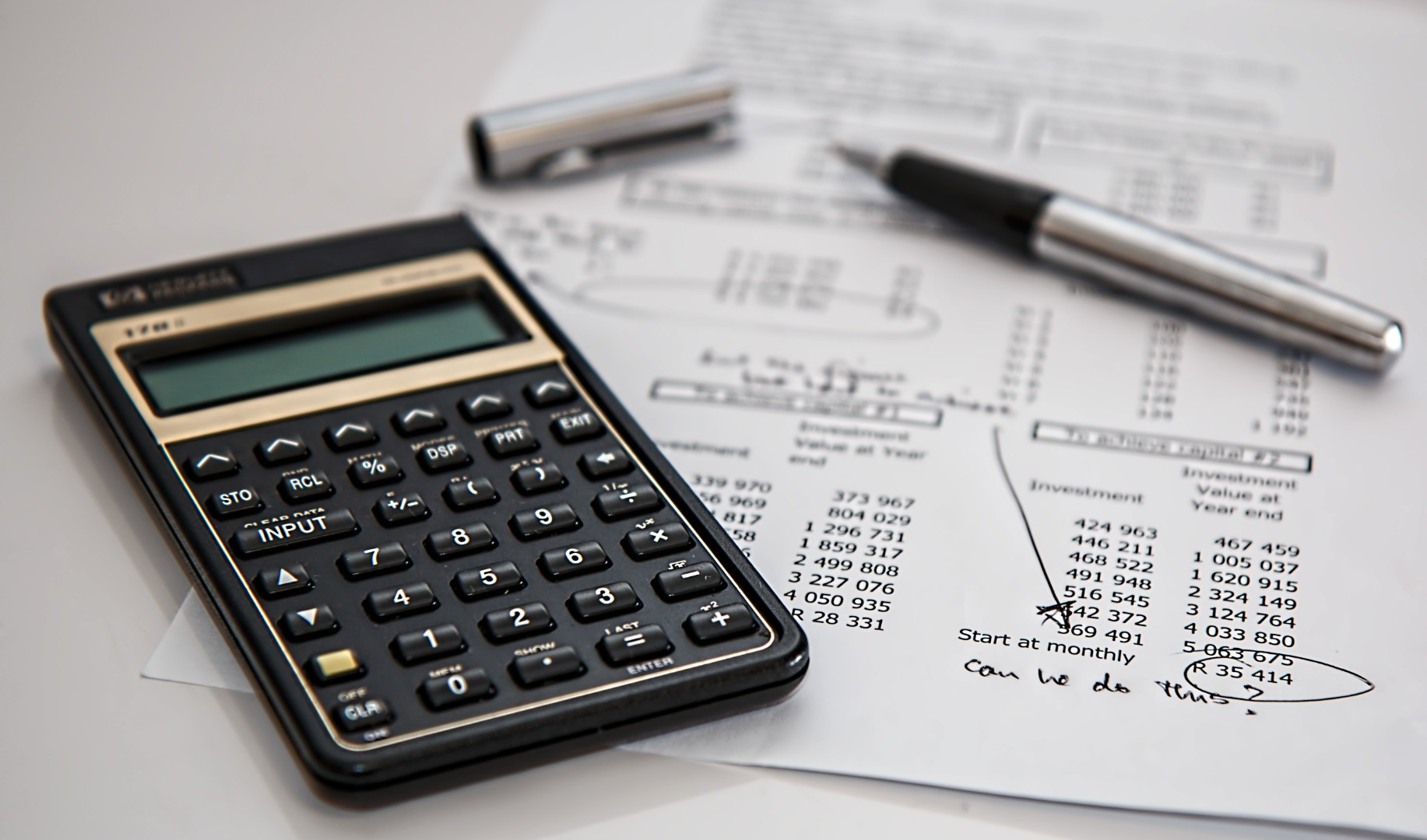 Stock image of calculator and financial documents on a desk